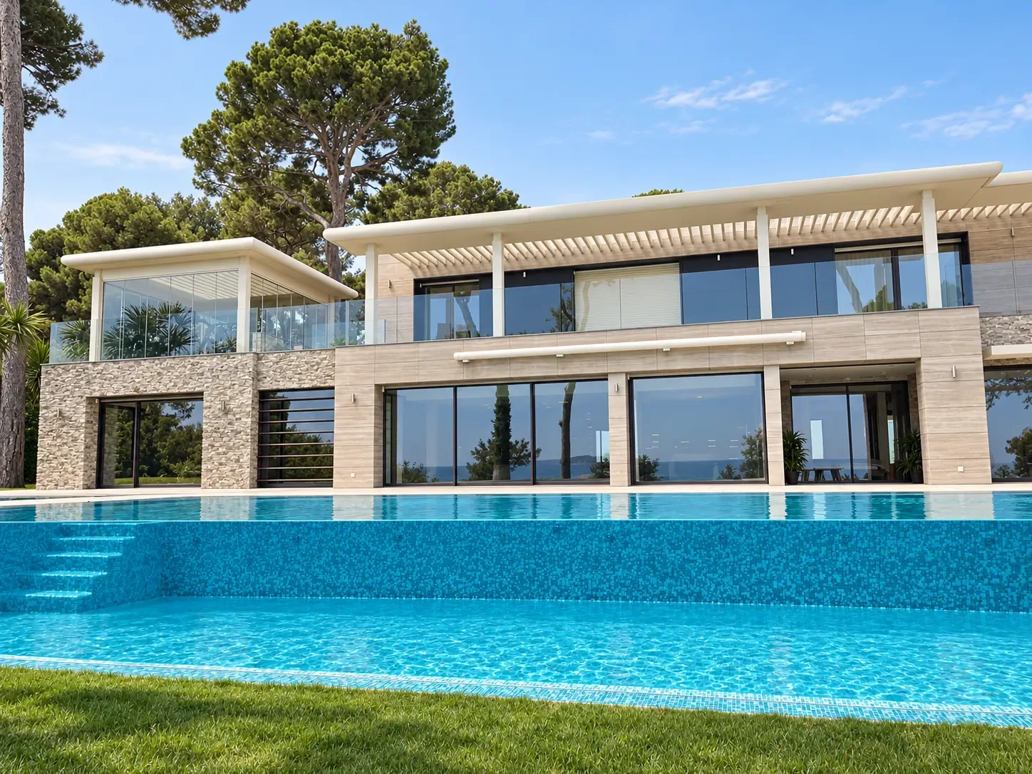 Garde-corps en verre et grandes baies vitrées sur une villa avec piscine.