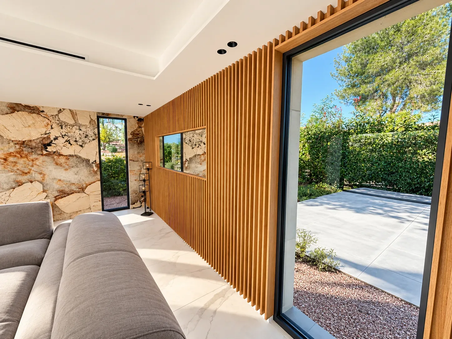 Grande baie vitrée à cadre sombre dans un intérieur habillé de bois.